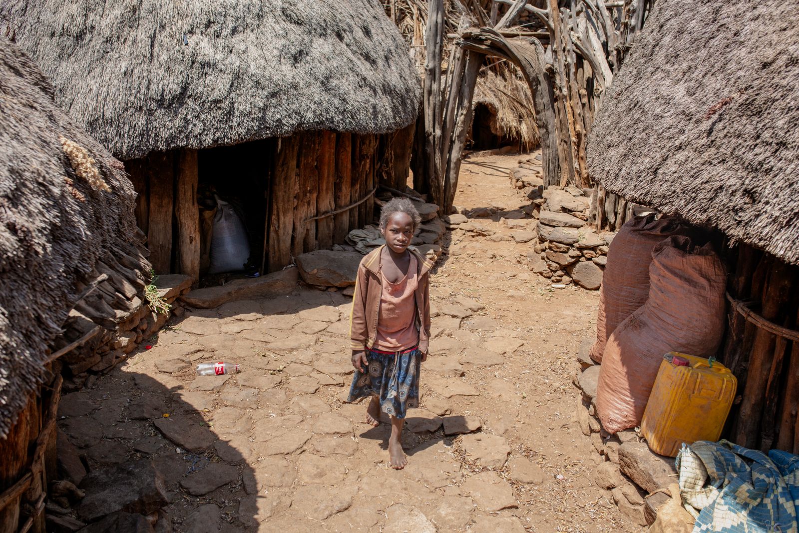 A child outside a home in a traditional village